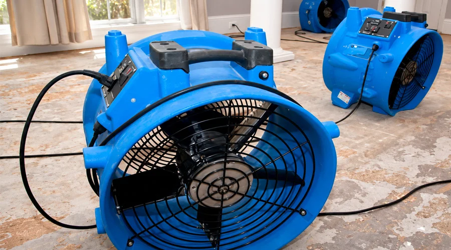 Professional air movers drying a water damaged residential interior